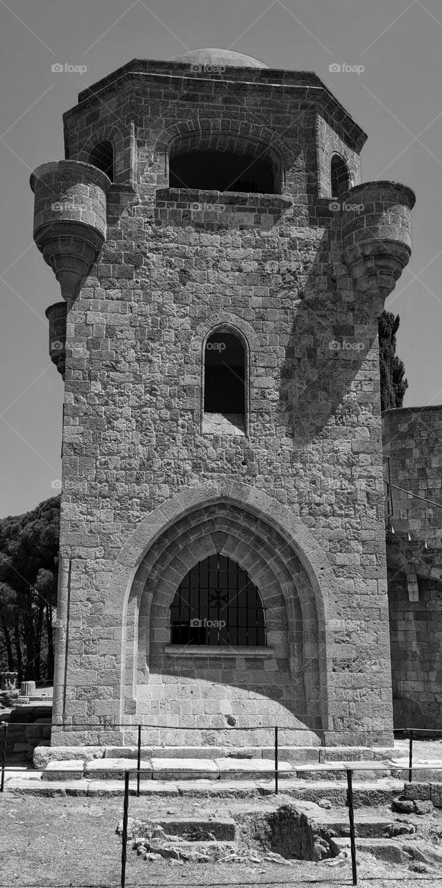 Beautiful view of the stone medieval citadel of the crusaders on a sunny day on Mount Filerimos Rhodes island Greece, close-up side view. The concept of the architecture of ancient castles and citadels.