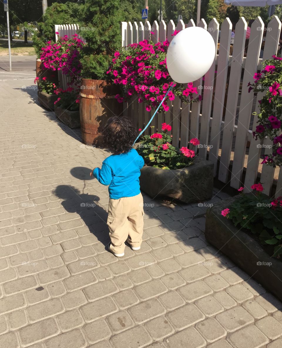 Rear view of a child holding balloon
