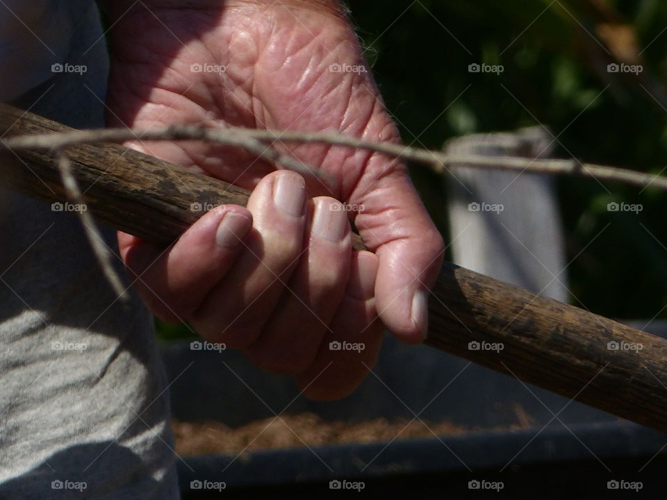 One hand gripping shovel