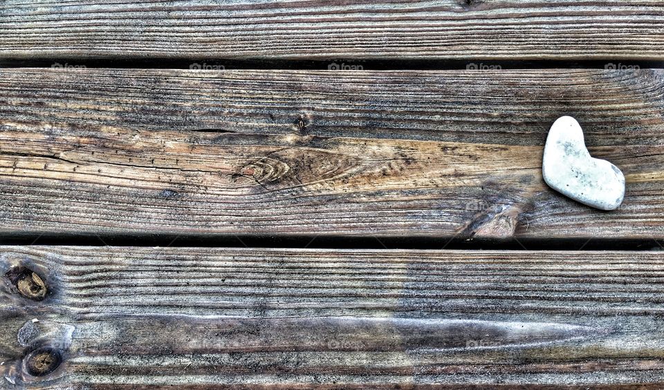 Heart shape stone on wooden background