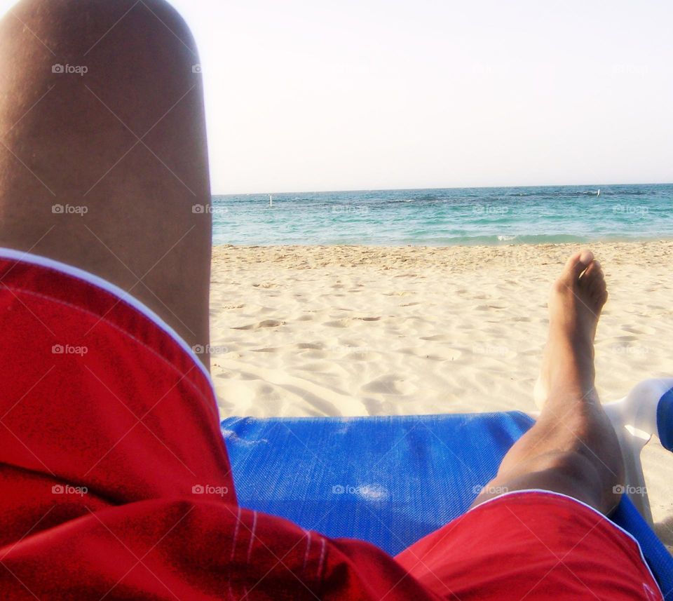 summertime at the beach a man wearing red and white swim trunks