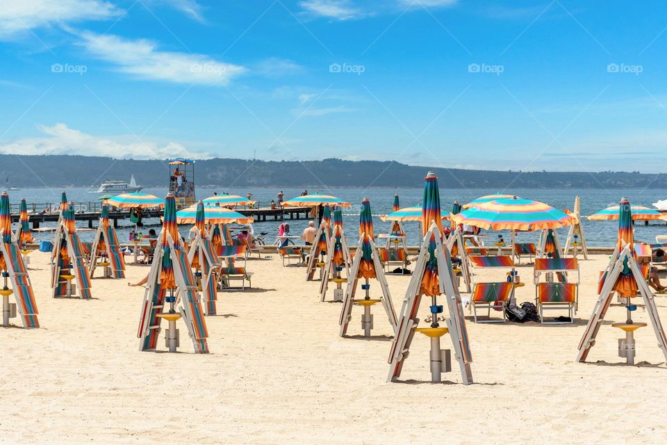 Deck chairs and umbrellas folded on sandy beach in resort