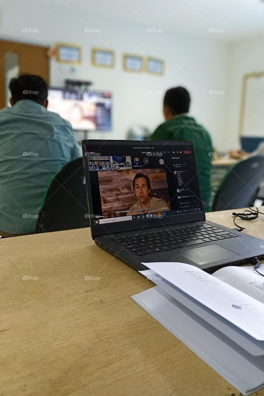 Bandar Lampung, Lampung, Indonesia - December 15, 2023: an individual sitting in a meeting room with a laptop open in front of him