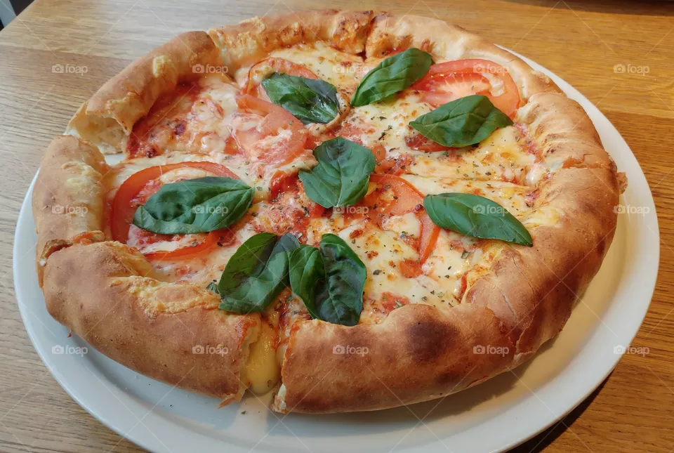 A stuffed-crust pizza topped with mozzarella, tomatoes and basil.
