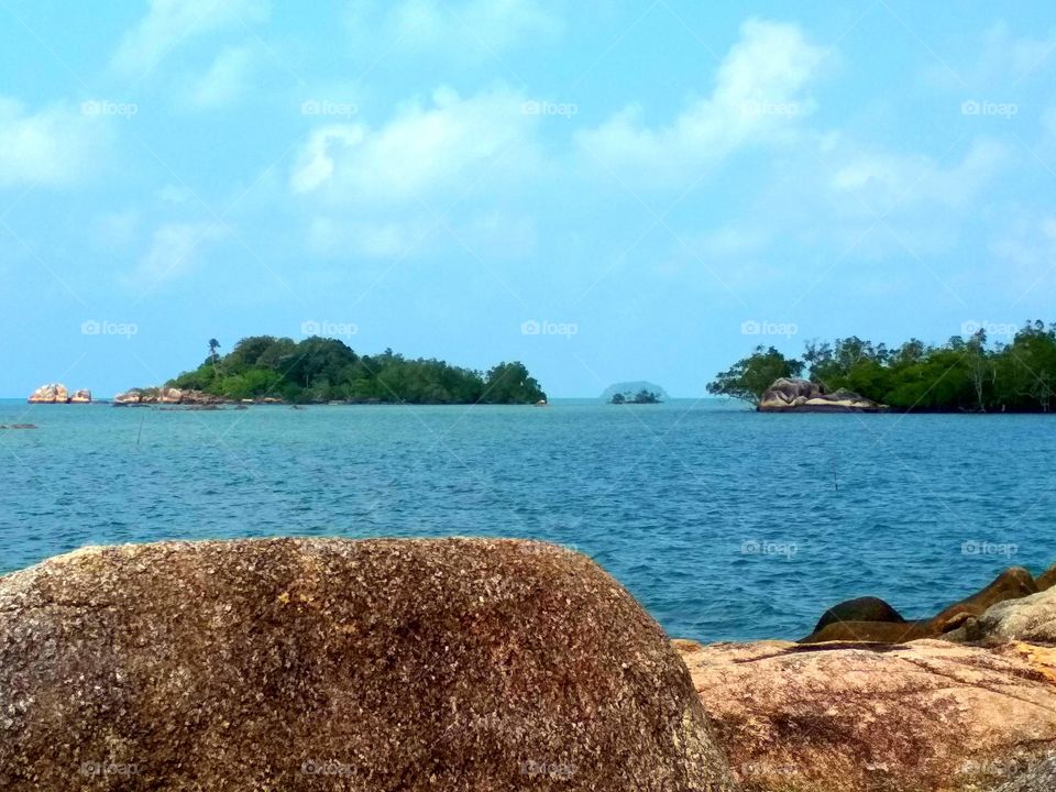 Beach on blue with rocks and islands