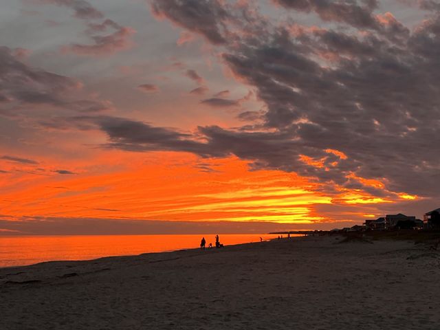 Vibrant red and orange sunset sky and clouds on a beach