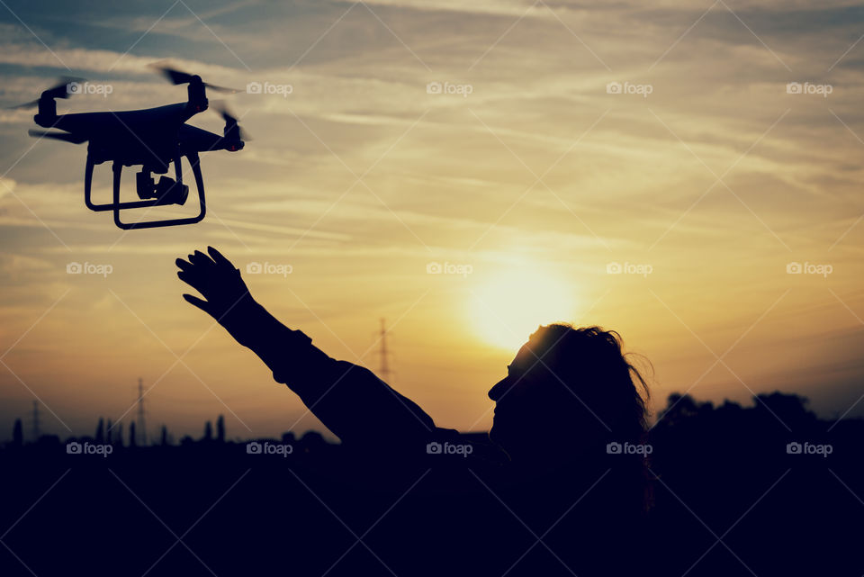 silhouette of a woman catching a drone