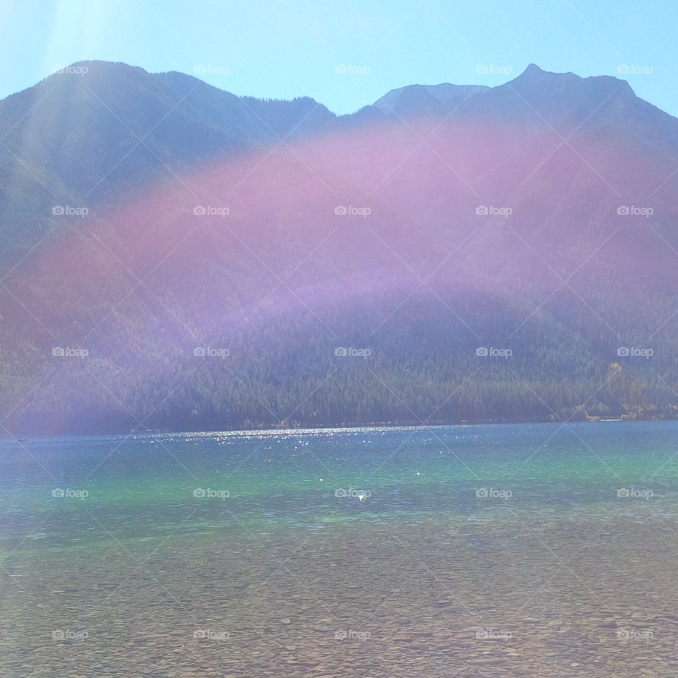 Rare Photo of Sunshine Rainbow over a Crystal Clear Mountain Lake