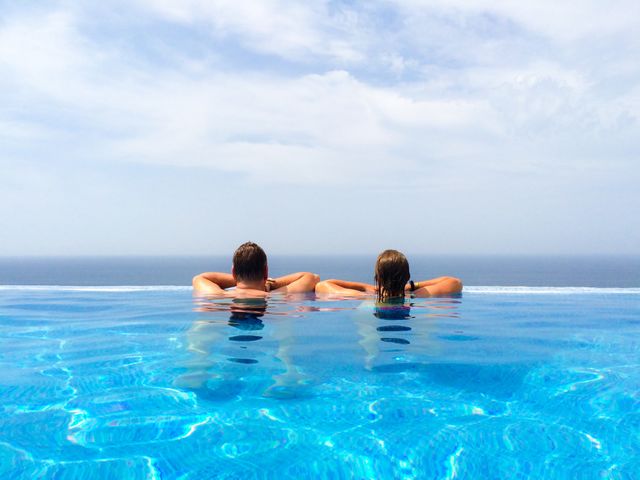 Rear view of couple in infinity pool