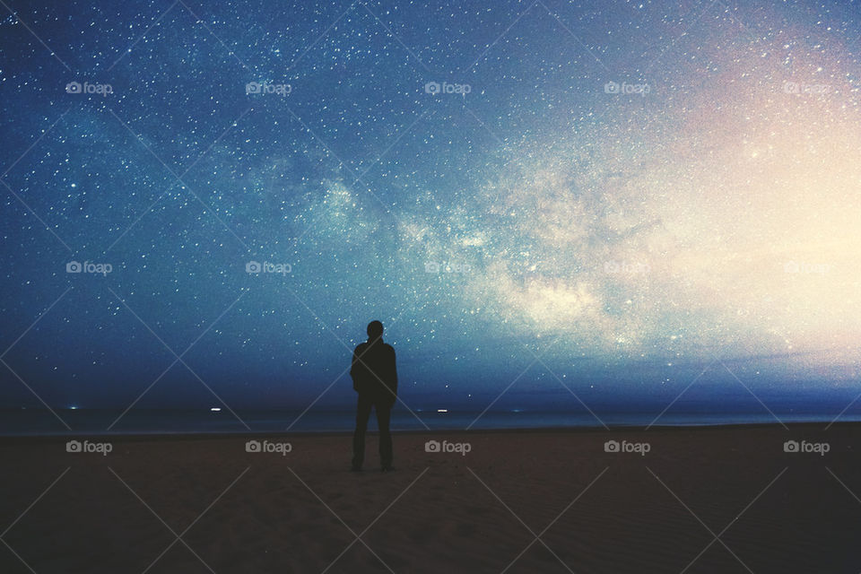 Silhouette of a man looking at milky way in sky