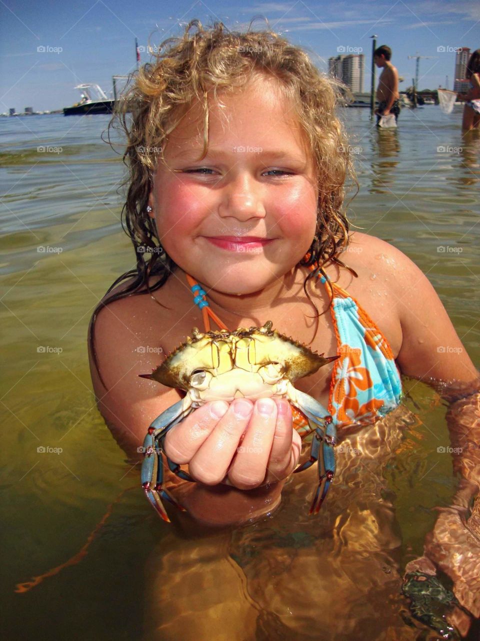 child holding blue crab