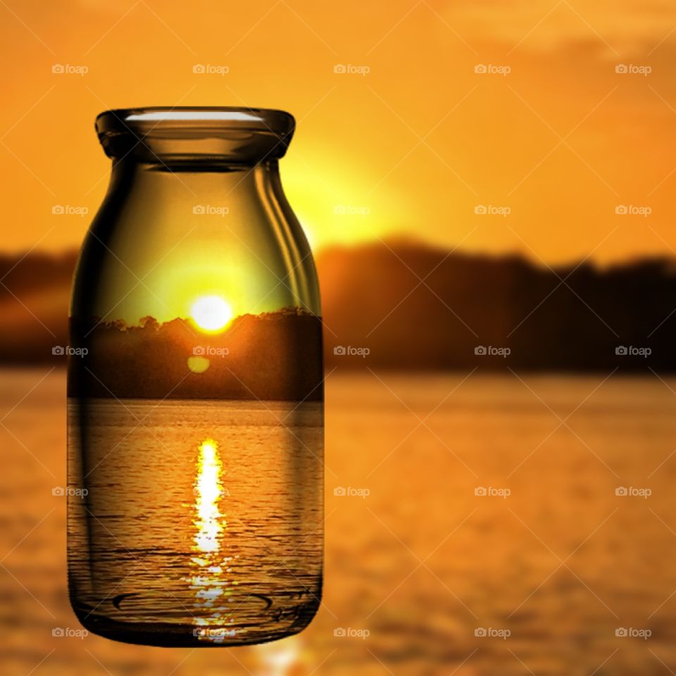 View of sunset through glass bottle