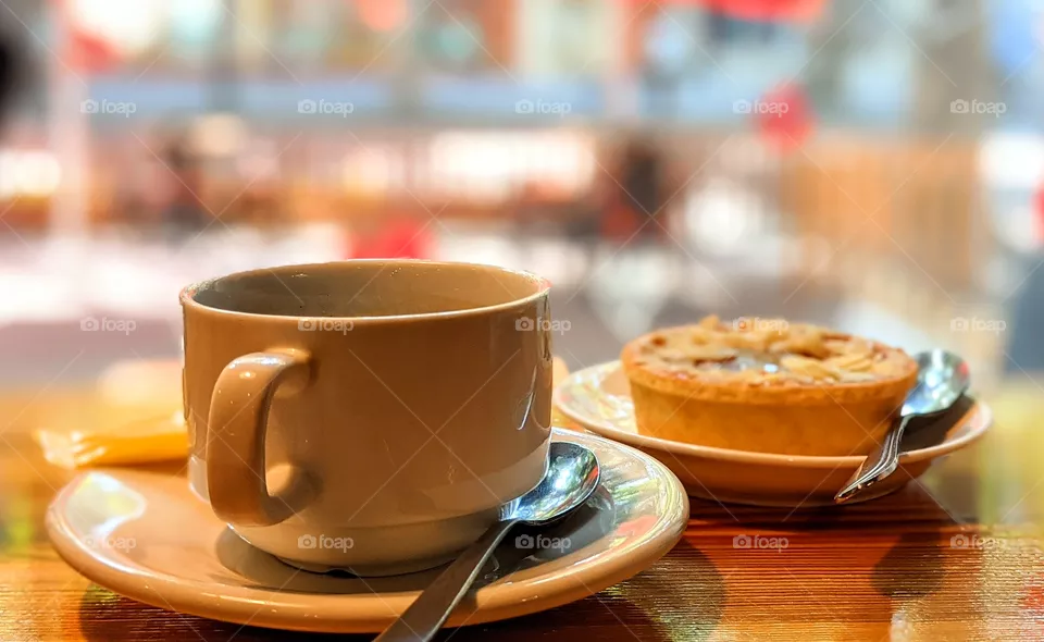 A cup of coffee and tarte dessert in a cafe