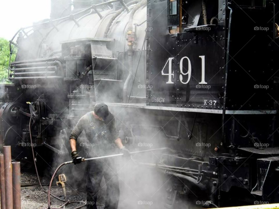 Colorado Train Museum. They were getting a steam engine ready for an event they were having the following day. I loved watching this worker prepare the engine. Every now and then they would let the steam escape and it would make this huge noise.
