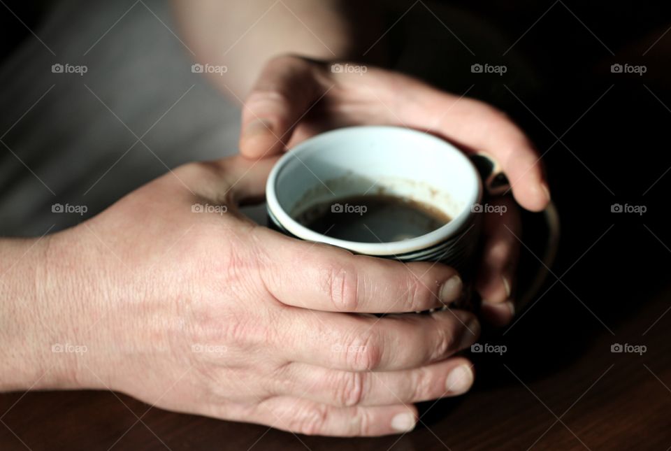 Cup of coffee with human hand