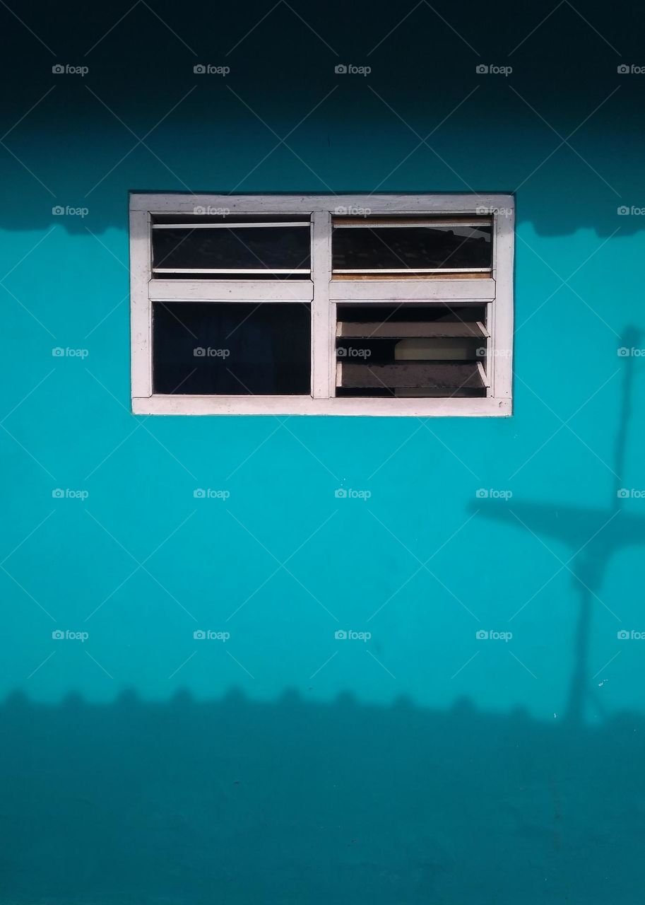 the windows and walls of a house are illuminated by the bright and warm light of the sun.