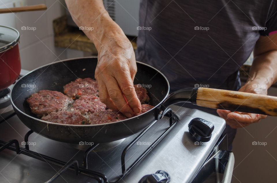putting the meat dumplings in the skillet.