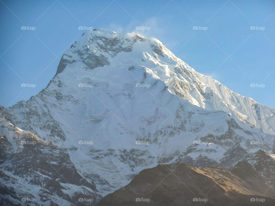 The wind blowing snow off the summit of Annapurna South. Photo taken on the Annapurna Base Camp Trek in Nepal.