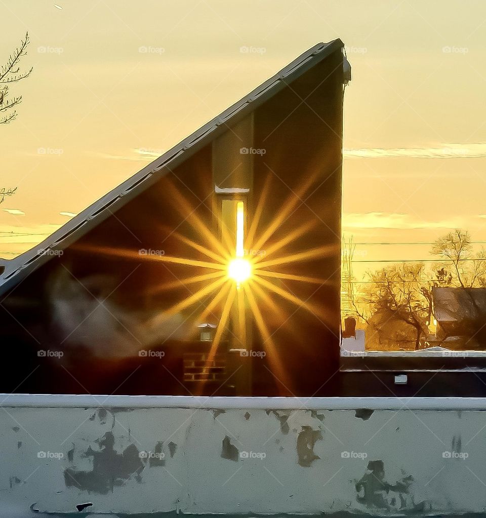 A classic sun star created by capturing the setting sun through a roof top window.