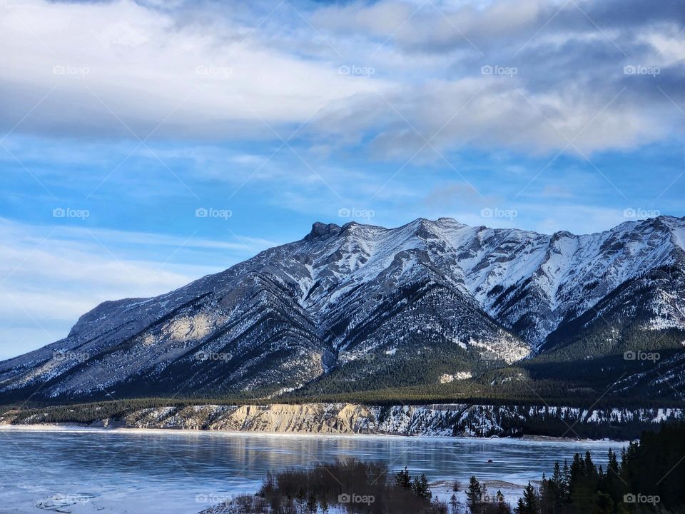 Frozen lake water under towering mountains