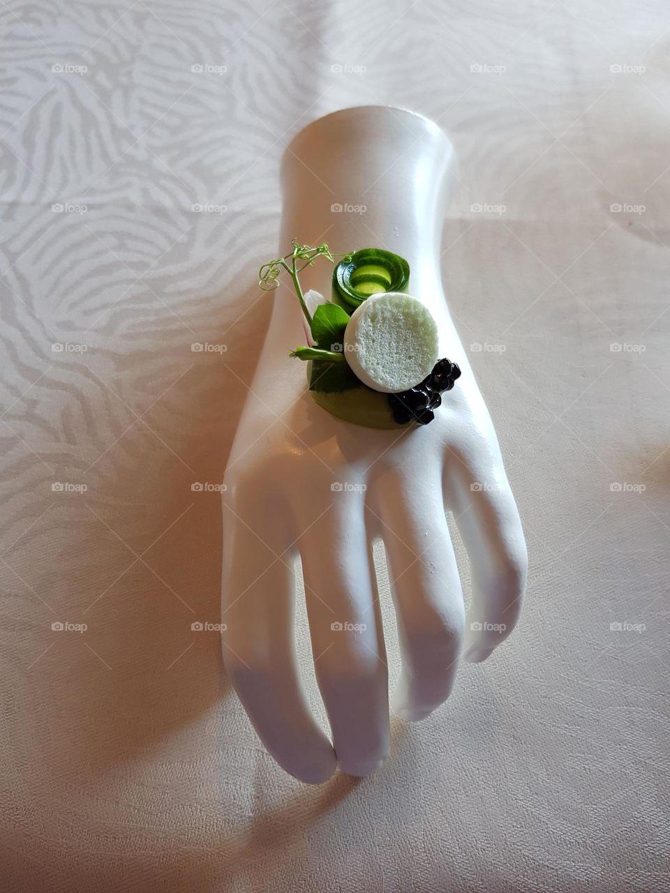 Delicious appetizer or amuse served on a (artifical) hand