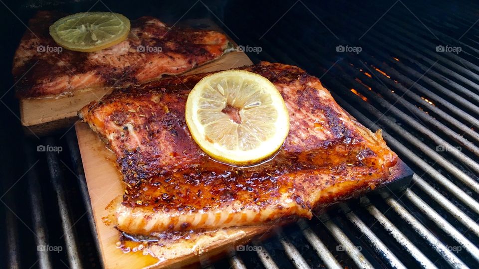 Lemon slice on seasoned BBQ cedar plank salmon