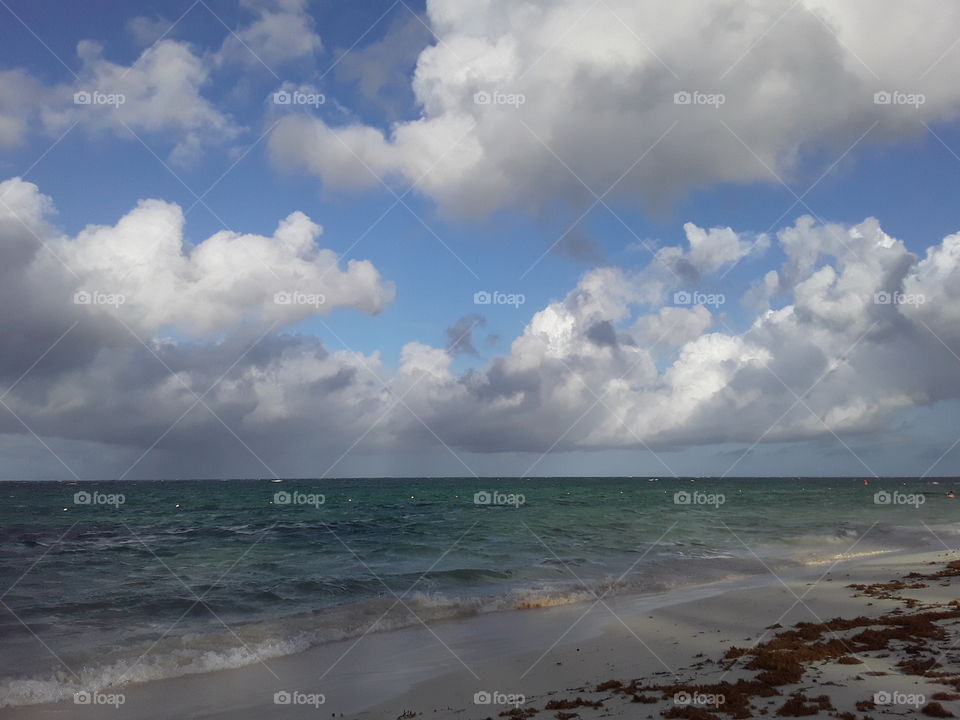 clouds gracefully floating in the sky adorn the ocean very beautifully