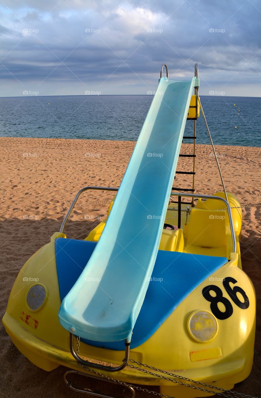 Yellow pedal boat on the beach