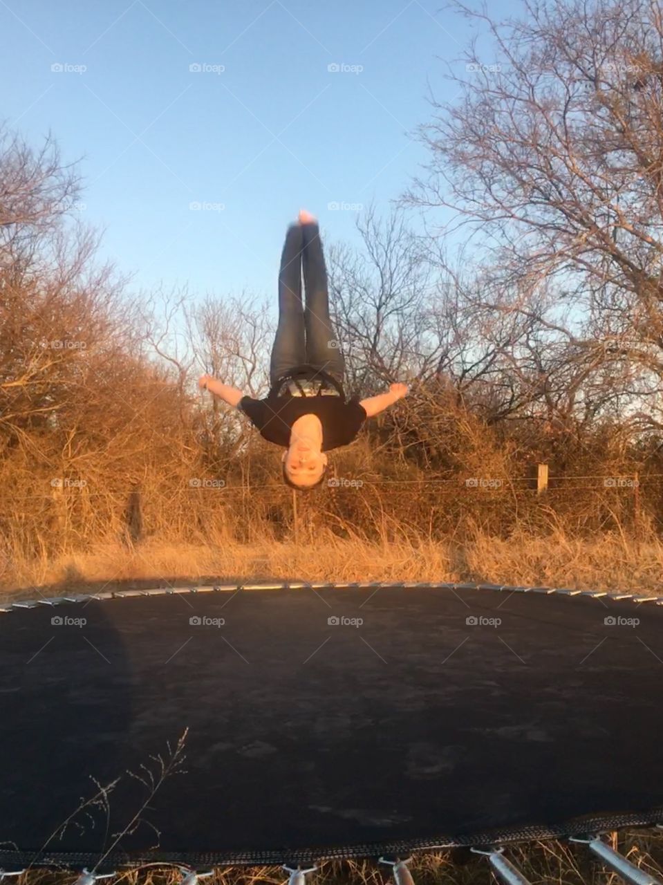 Girl flipping on trampoline upside down 