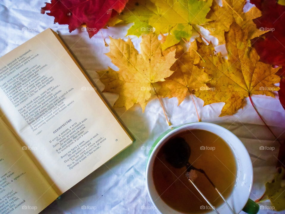 colorful autumn leaves, a cup of tea and a book