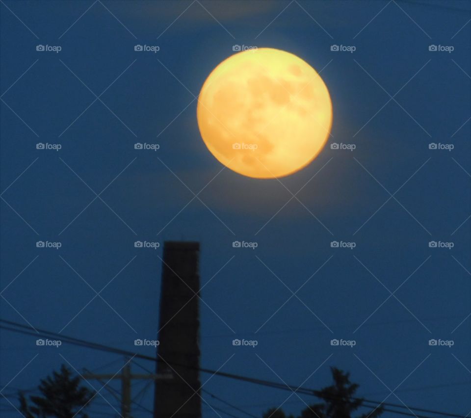 Full moon over smoke stack