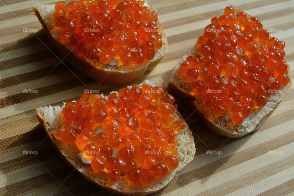 sandwiches with red caviar wood table background