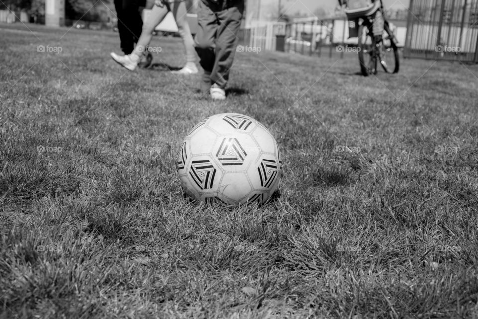 Ball on the football field. Green grass on football field, kids playing with a ball