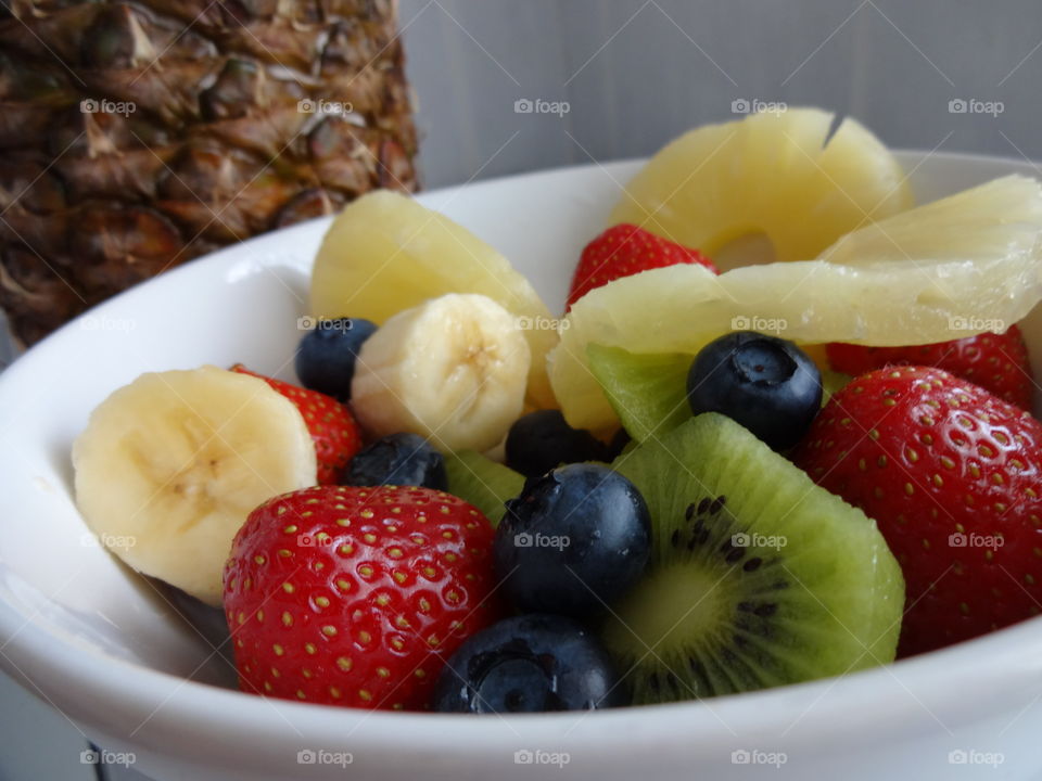 Healthy fruits breakfast full of vitamins with strawberry, kiwi, banana, pineapple and berries