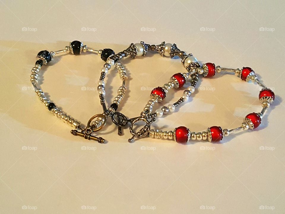 Homemade bracelets in red, silver, black and white.
