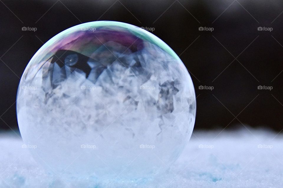 Frozen bubble sitting on the snow