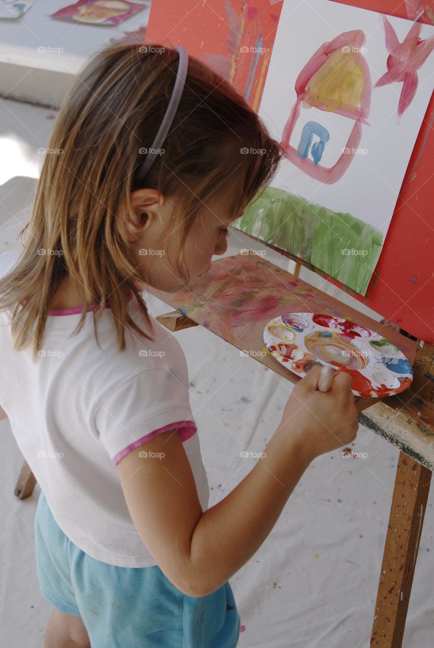 Little girl, painting at easel, creativity with kids