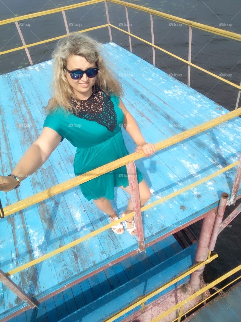 a girl on a blue pier and wearing glasses