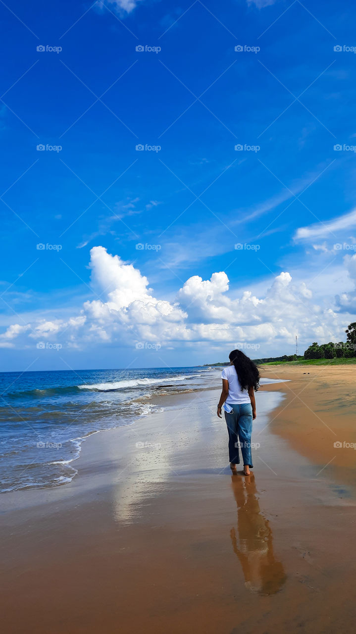 Walk along a magical beach surrounded by beautiful blue ocean, white smooth waves and golden sandy beach with water reflects what you are. Seing double.