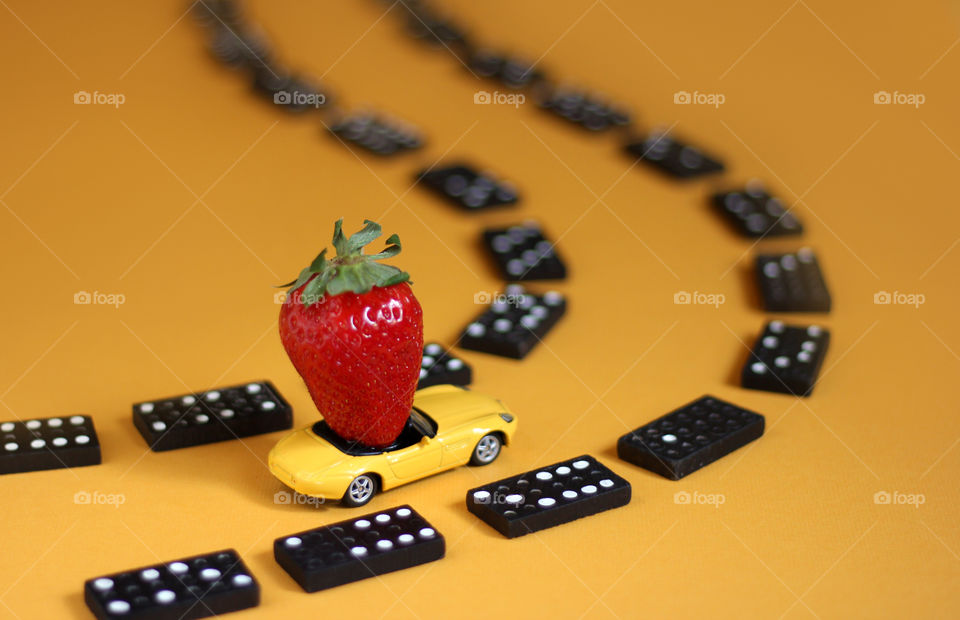 Toy car and strawberry in it and domino