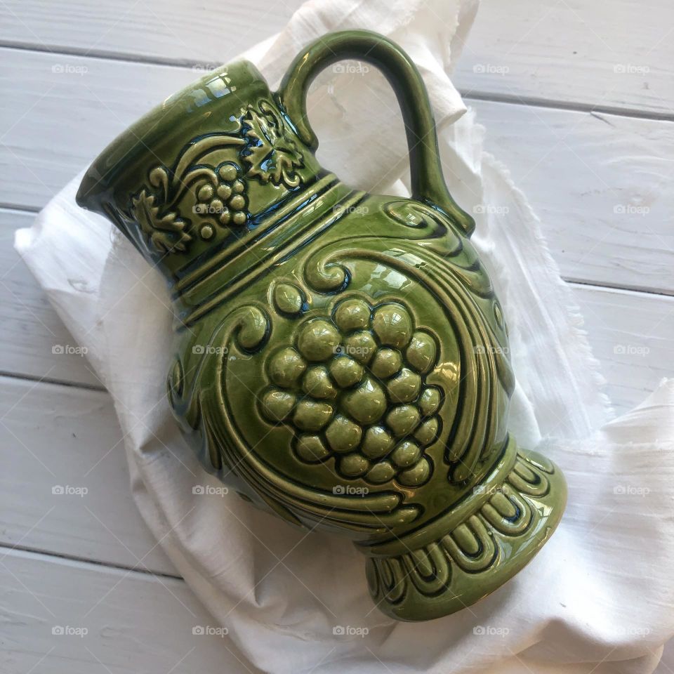 Old ceramic decanter in green color