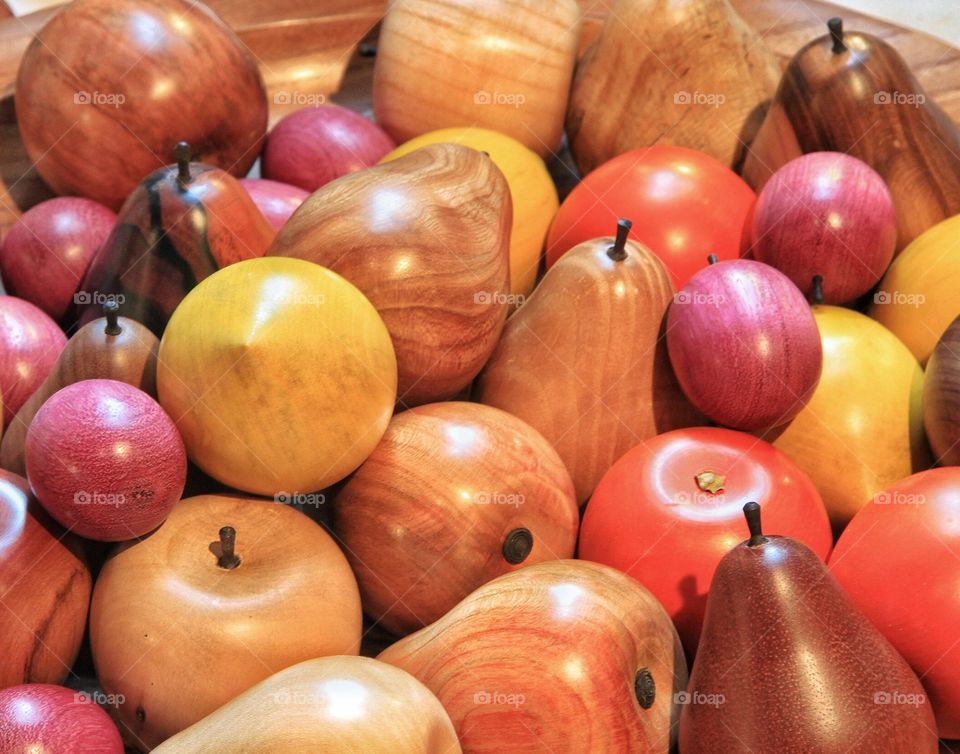 Wooden Fruit. A bowl of wooden fruit including apples, oranges, pears, lemons and plums.