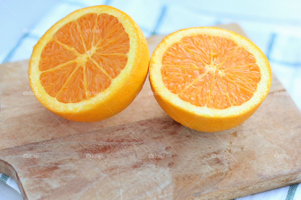 Halved oranges with cutting board