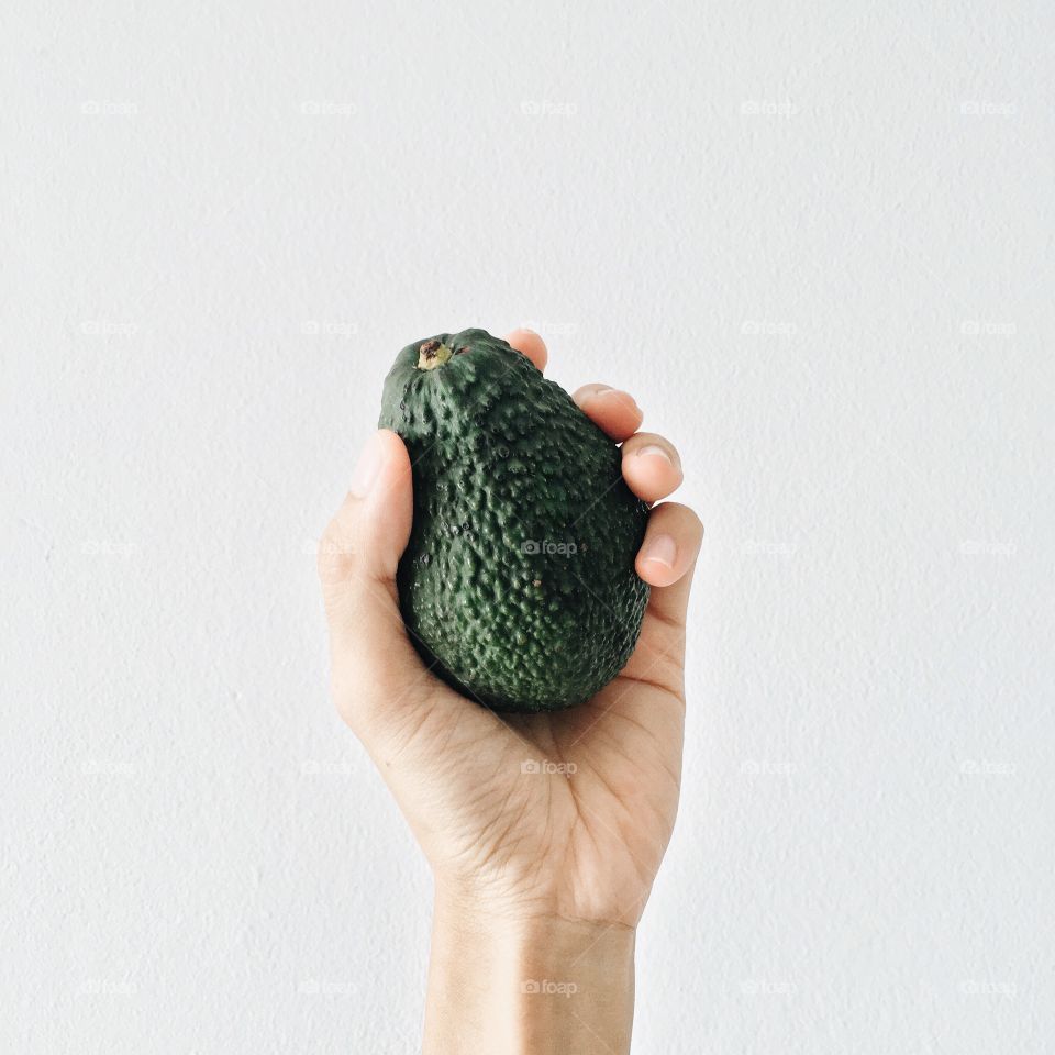 Human hand with hass avocado