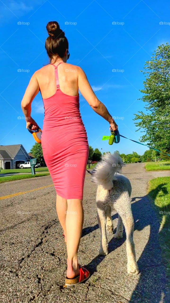 beautiful woman walking dog in a dress