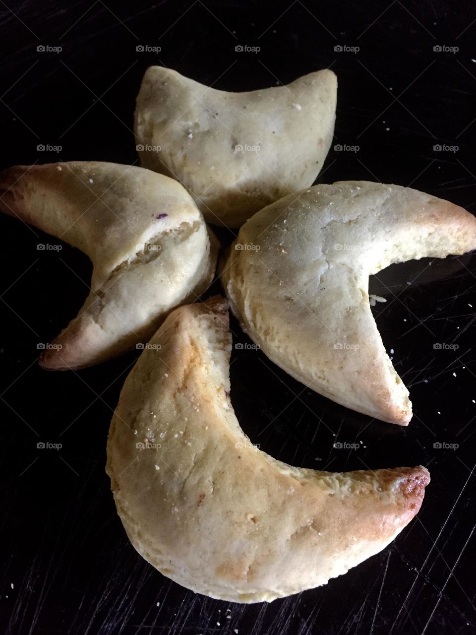 A halfmoon cookies that formed like a tree on the top of a wooden chopping board.