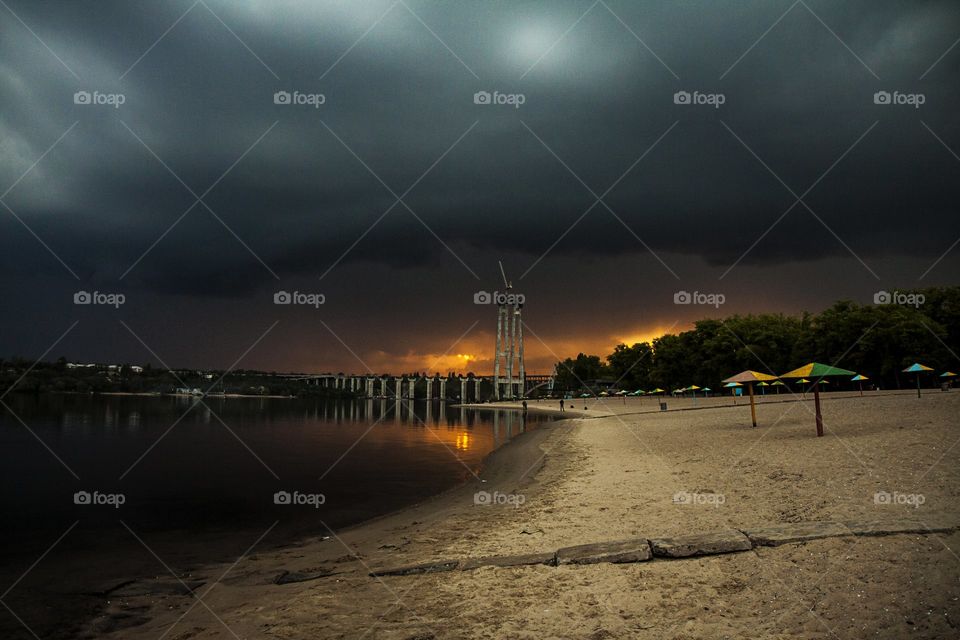 dramatic sunset near the unfinished bridge on the river