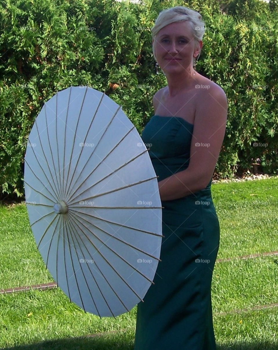 Woman wearing green dress holding parasol 