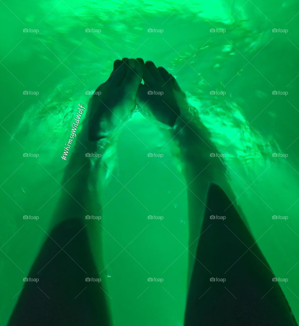 Curved feet enjoying the warmth of the hot tub in the laye evening. Enjoying the deep, green glow that adds a mysterious feeling.