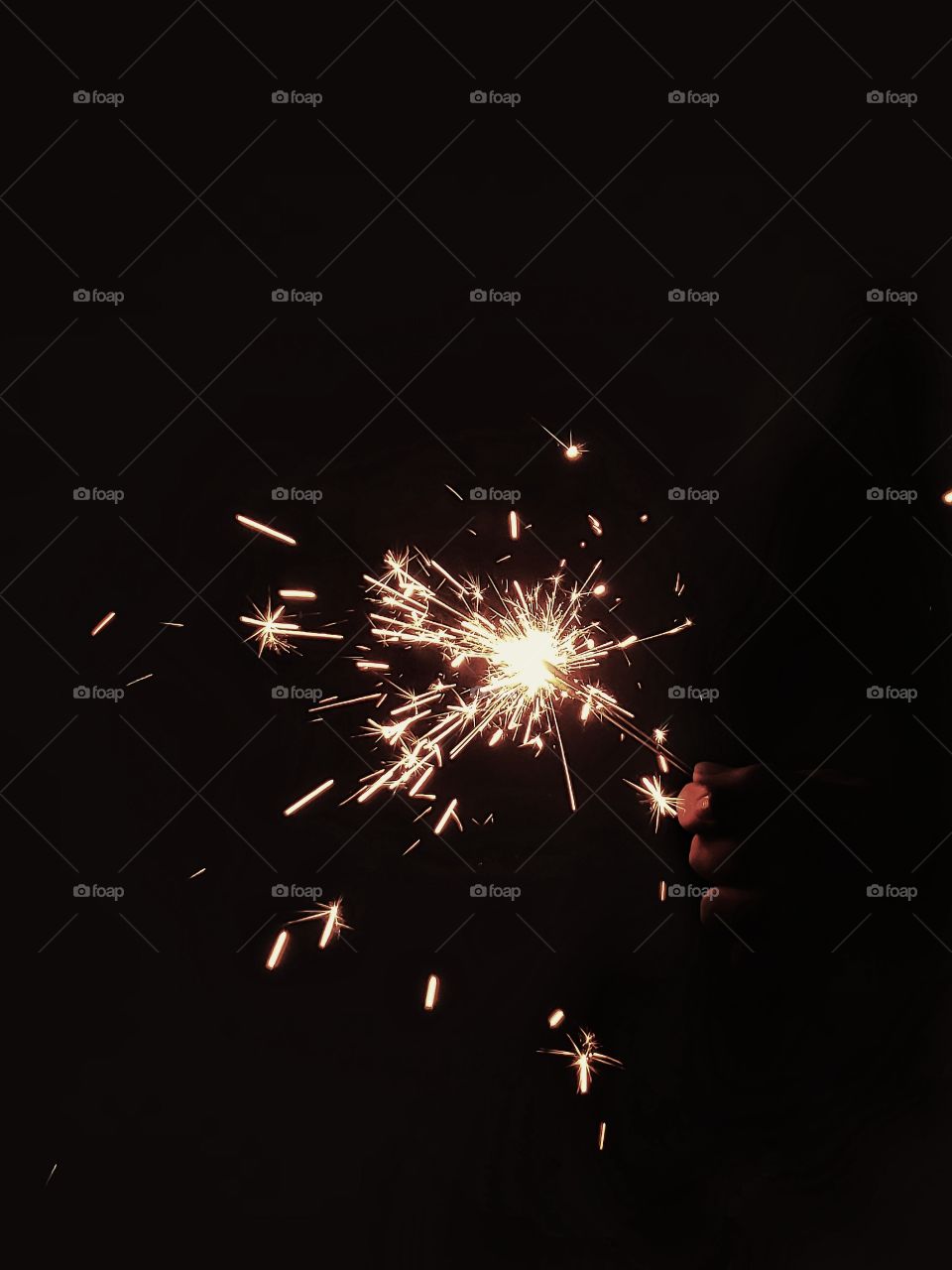 A burst of a sparkler during midnight, sending sparks all over. Taken with a Samsung Galaxy S9